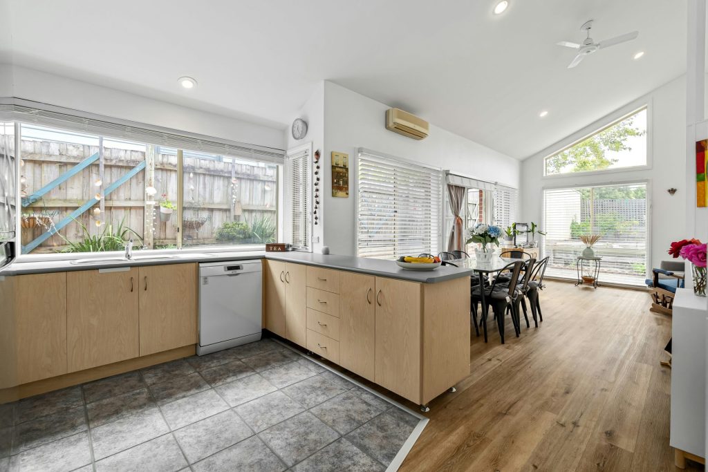 Une grande cuisine ouverte avec parquet et murs blancs