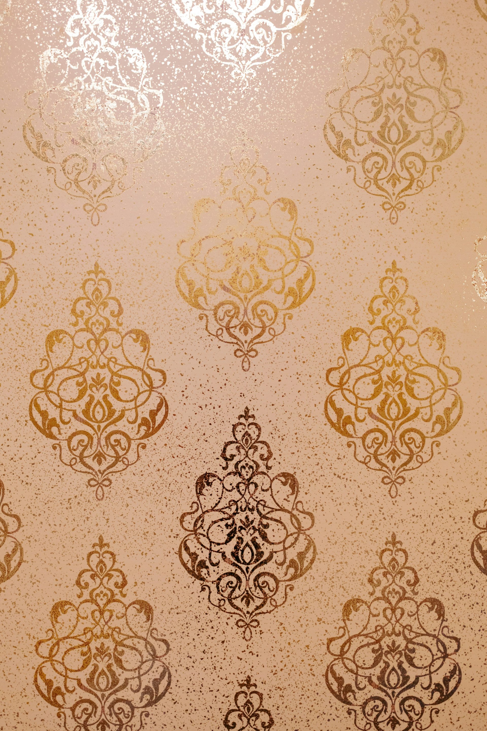 Gold ornate damask pattern on textured background