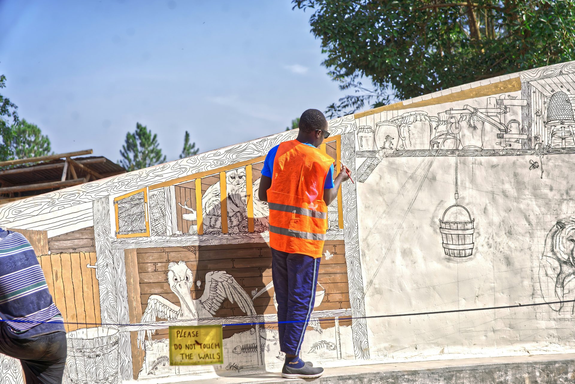 Man in safety vest painting a mural